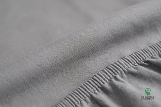 Gros plan sur le panneau supérieur du drap-housse et la couture latérale en coton élastiqué