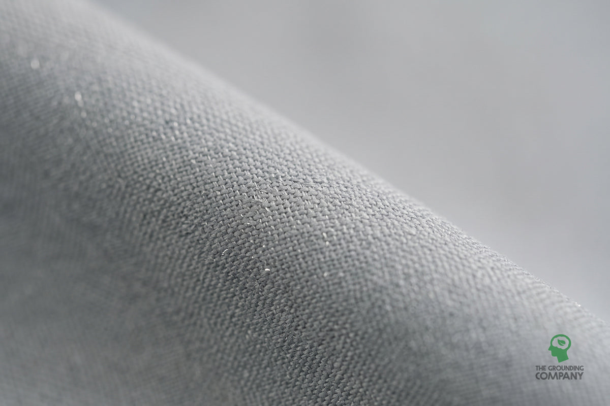 Close-up of the grey woven fabric on the Grounding Half Sheet, showing the fine silver conductive threads running through the weave.