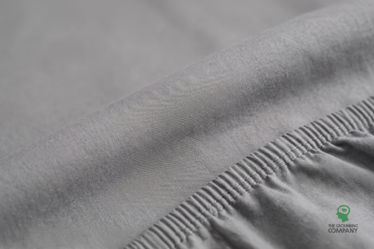 Close-up of the fitted sheet's top panel and elasticated cotton side seam