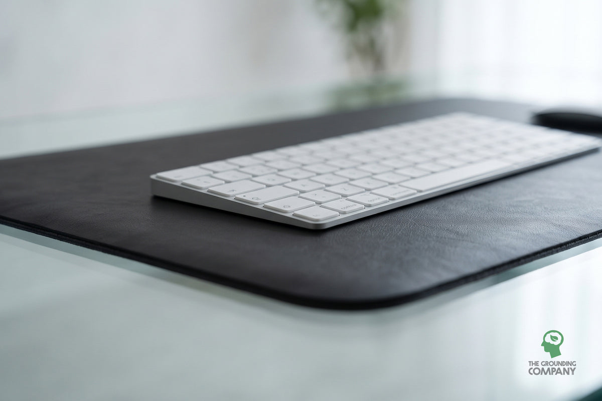 Close-up of a keyboard's edge on the mat's textured surface, on a glass desk