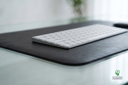 Close-up of a keyboard's edge on the mat's textured surface, on a glass desk